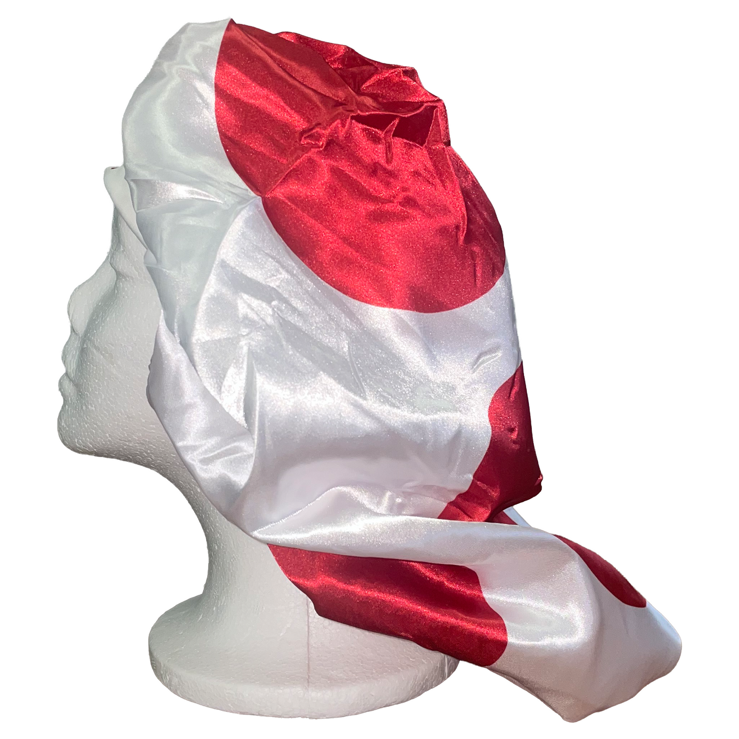 Red and white fabric draped over a mannequin head on a white background